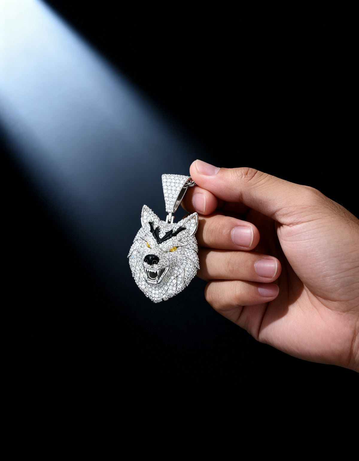 Iced Out 3D Wolf Head Pendant held in hand in a soft beam of light