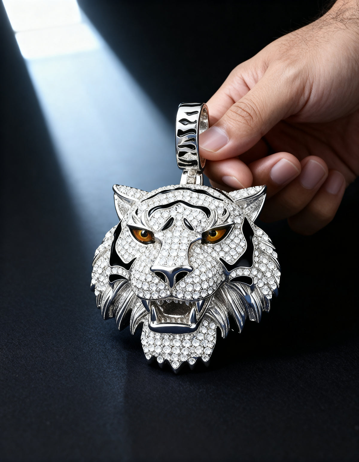 Moissanite Tiger Pendant in 925 silver - held in hand in a soft beam of light