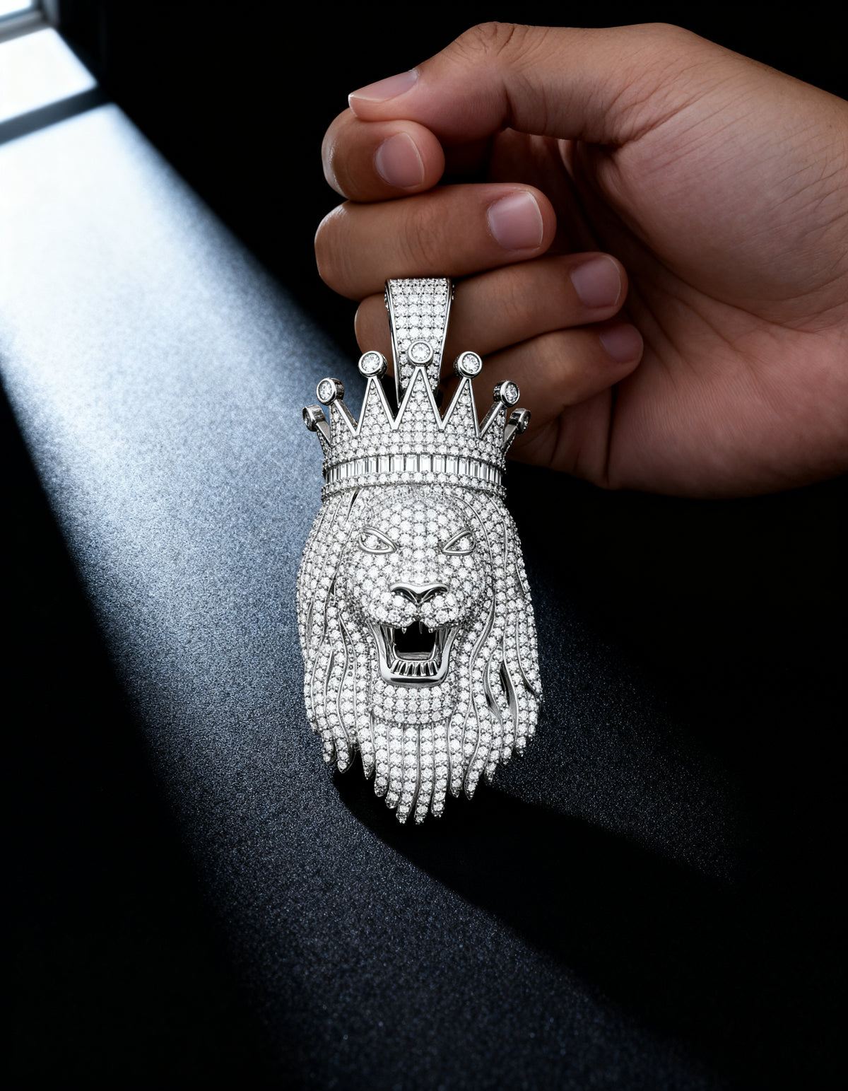 Crown Lion Pendant in 925 silver with moissanite - held in hand in a soft beam of light