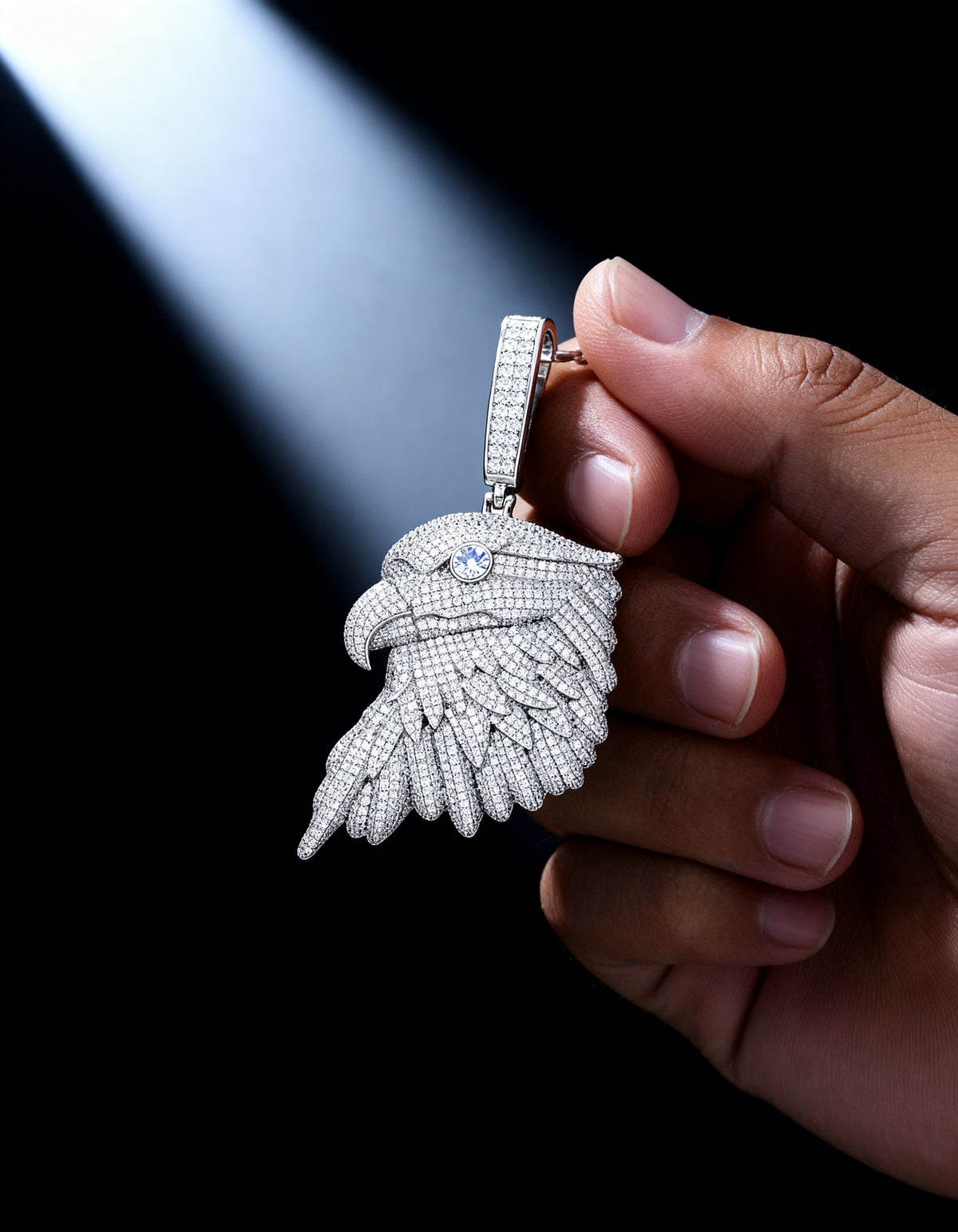 Iced Out Bald Eagle Pendant in 925 silver with moissanite - held in hand in a soft beam of light