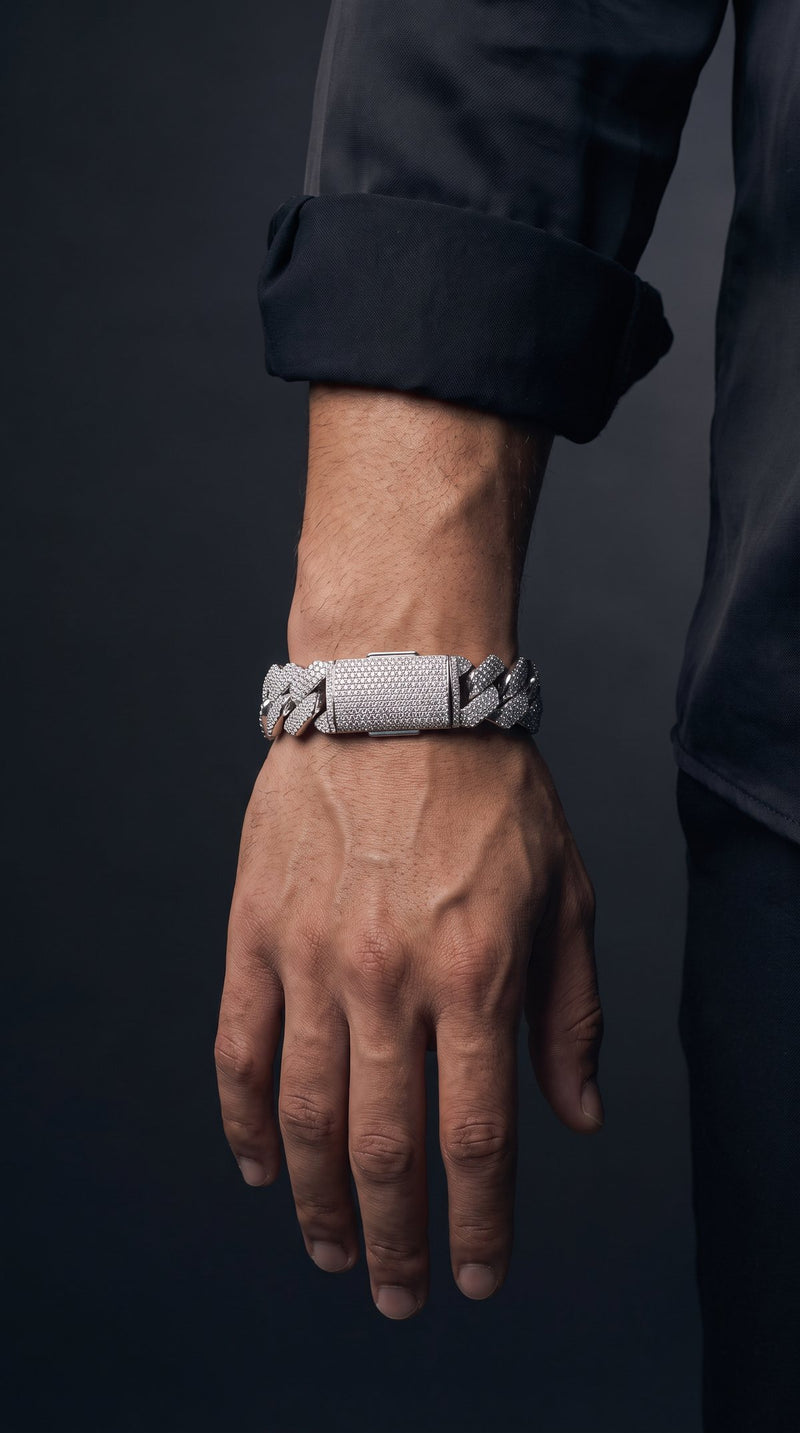 Man's wrist wearing a wide iced-out Cuban link bracelet