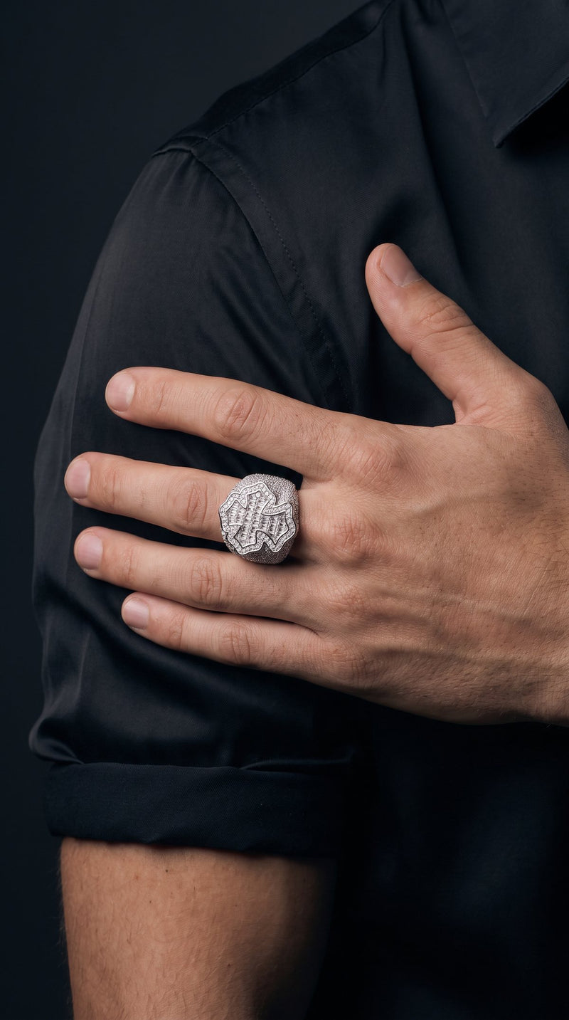 Man's hand wearing an iced-out baguette cross ring