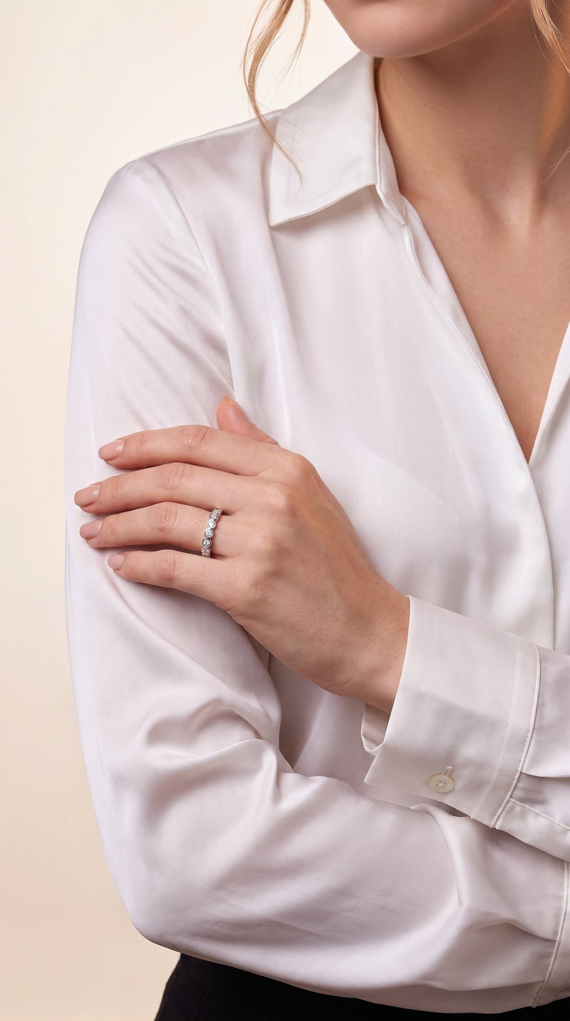 Woman's hand wearing a bezel set moissanite eternity band on her ring finger