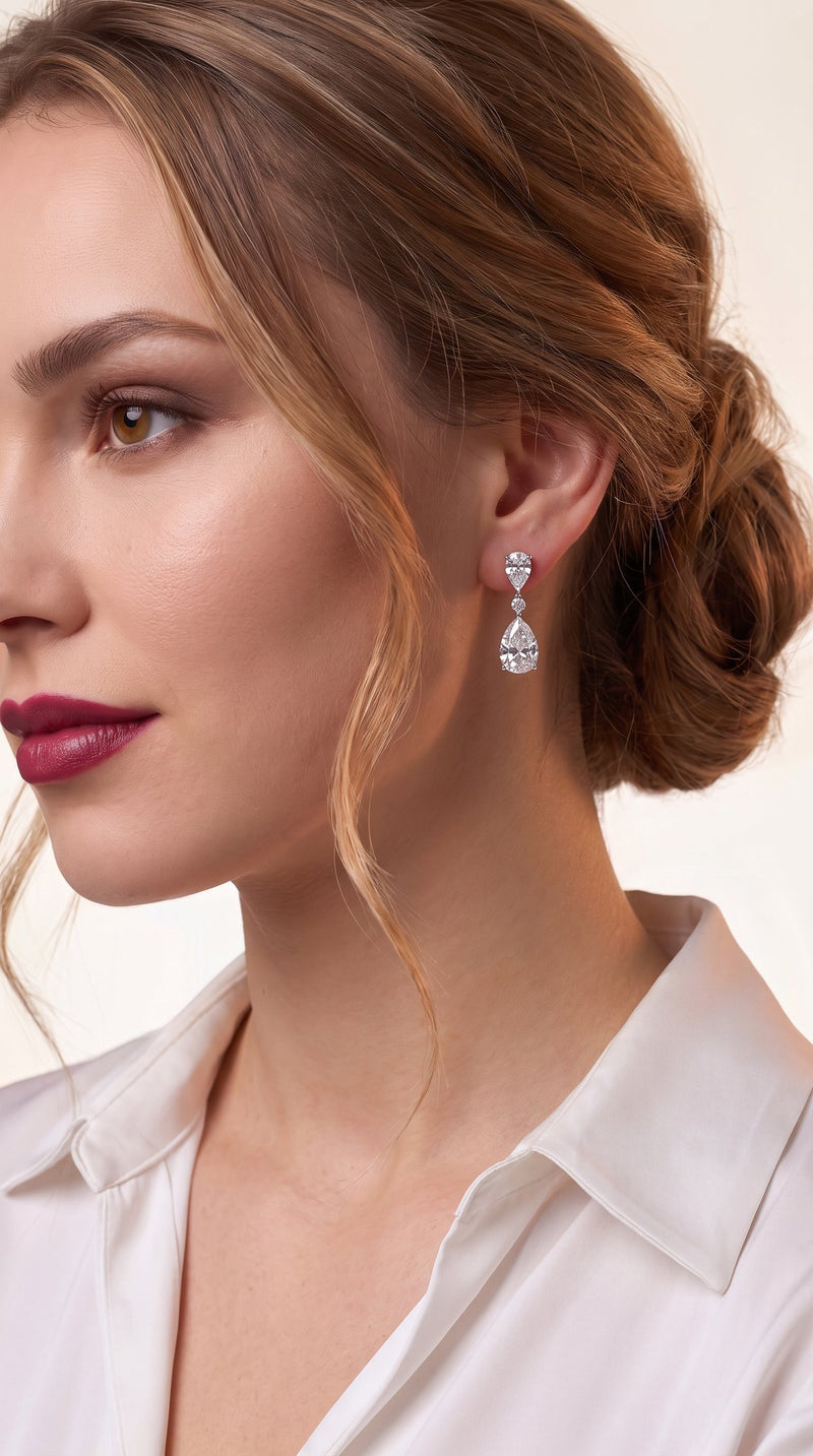 Profile of a woman wearing pear cut moissanite drop earrings